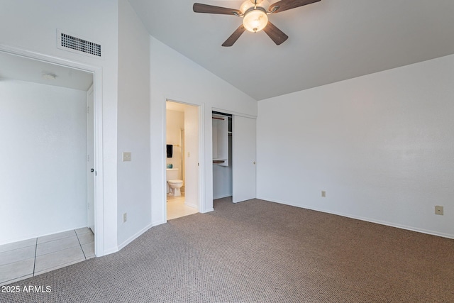 unfurnished bedroom with lofted ceiling, ceiling fan, connected bathroom, light carpet, and a closet