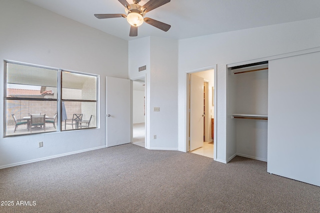 unfurnished bedroom with vaulted ceiling, connected bathroom, light colored carpet, ceiling fan, and a closet