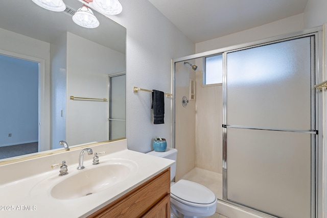 bathroom with vanity, toilet, and a shower with shower door