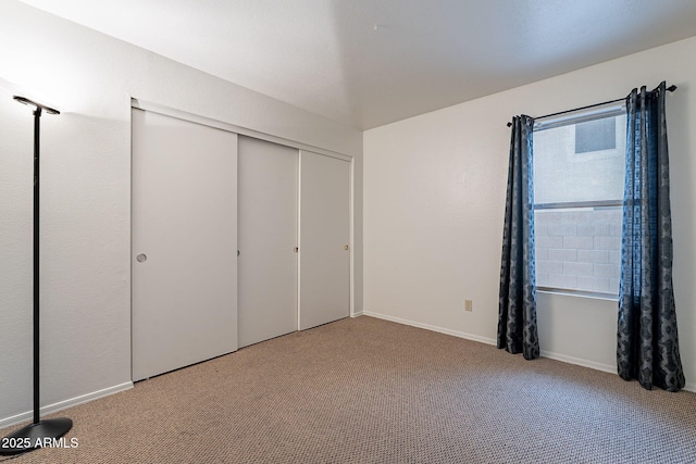 unfurnished bedroom with light carpet and a closet