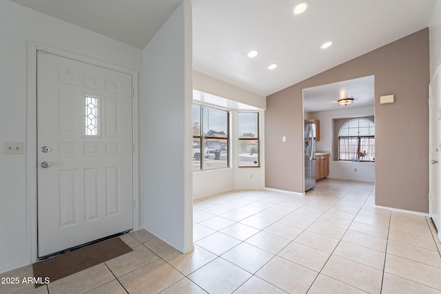 tiled foyer featuring lofted ceiling