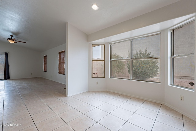 tiled spare room featuring vaulted ceiling, plenty of natural light, and ceiling fan