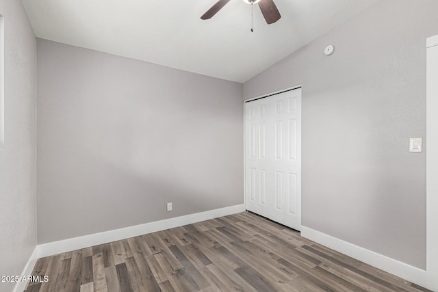 unfurnished bedroom with hardwood / wood-style flooring, vaulted ceiling, ceiling fan, and a closet