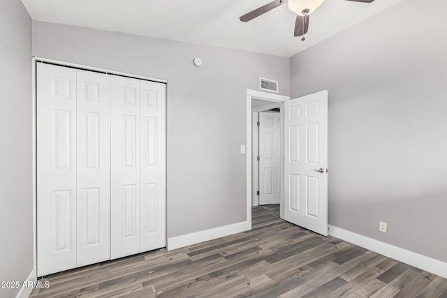 unfurnished bedroom with lofted ceiling, a closet, dark hardwood / wood-style floors, and ceiling fan