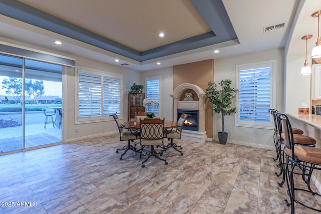 dining space with a raised ceiling