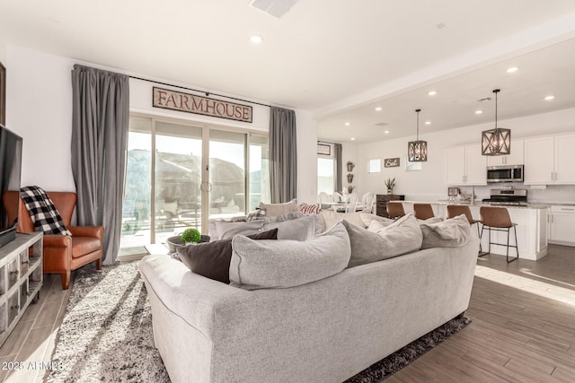 living area with light wood-style floors, recessed lighting, and visible vents