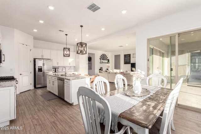 dining room with light wood-style flooring, visible vents, and recessed lighting