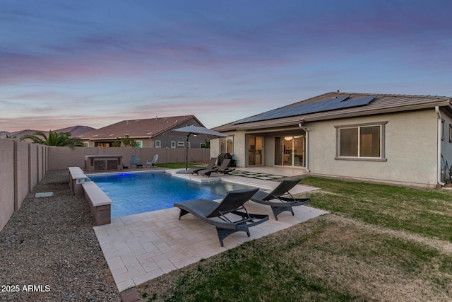 pool at dusk featuring a fenced backyard, a fenced in pool, a lawn, and a patio