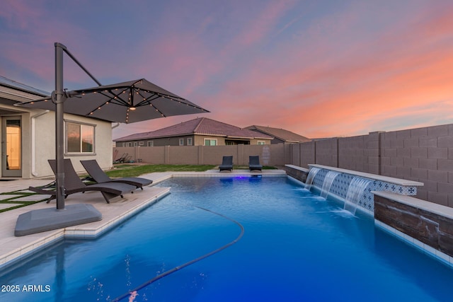 pool at dusk featuring a patio, a fenced backyard, and a fenced in pool