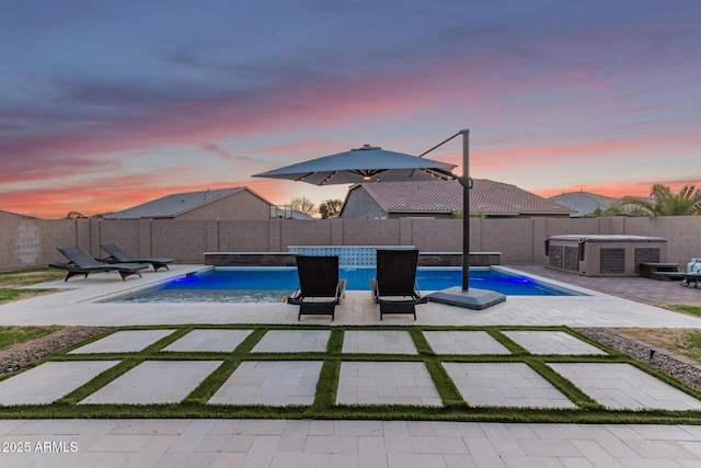 pool at dusk with a patio area, a fenced backyard, and a fenced in pool