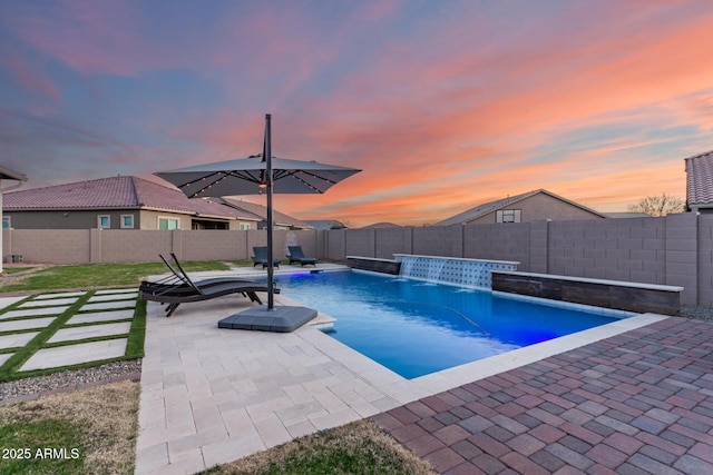 pool at dusk with a fenced in pool, a patio area, and a fenced backyard