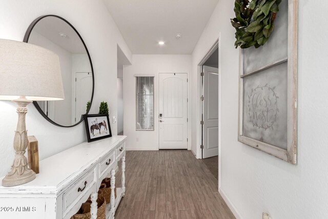 hallway with wood finished floors and baseboards