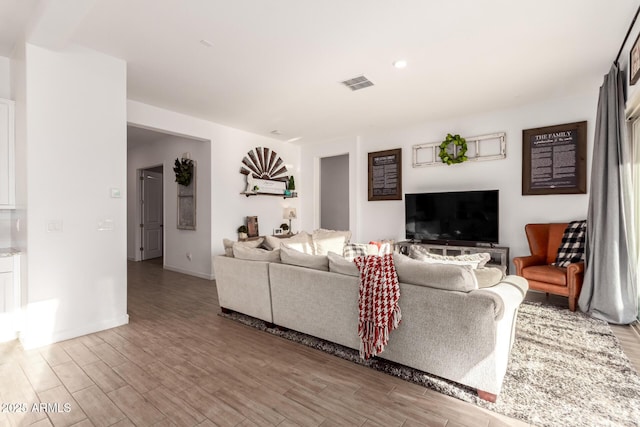 living area featuring light wood-style floors, baseboards, and visible vents