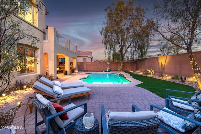 pool at dusk with a patio