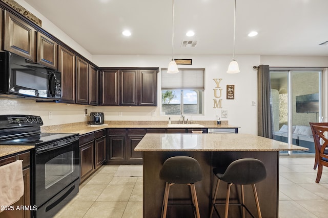 kitchen with sink, a center island, dark brown cabinetry, black appliances, and decorative light fixtures