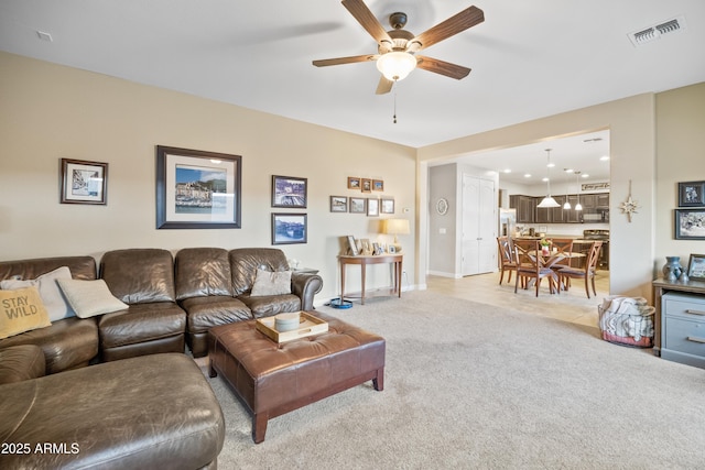 living room featuring light carpet and ceiling fan