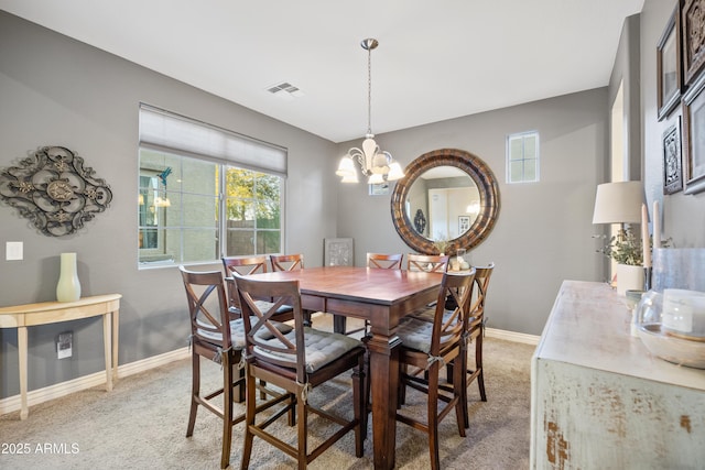 dining room featuring light colored carpet and a notable chandelier