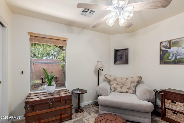 living area featuring a ceiling fan, wood finished floors, and baseboards