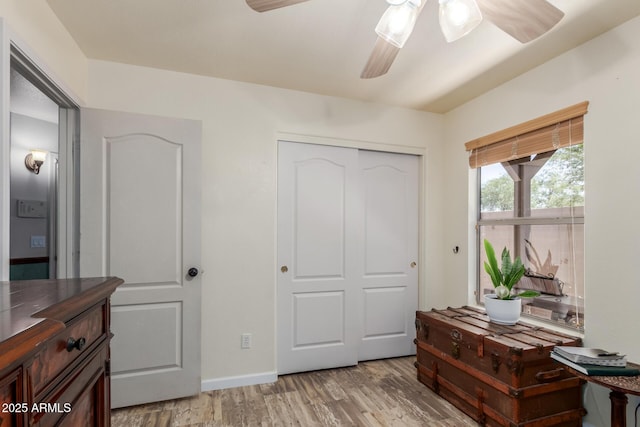 bedroom featuring light wood-style flooring, a closet, ceiling fan, and baseboards
