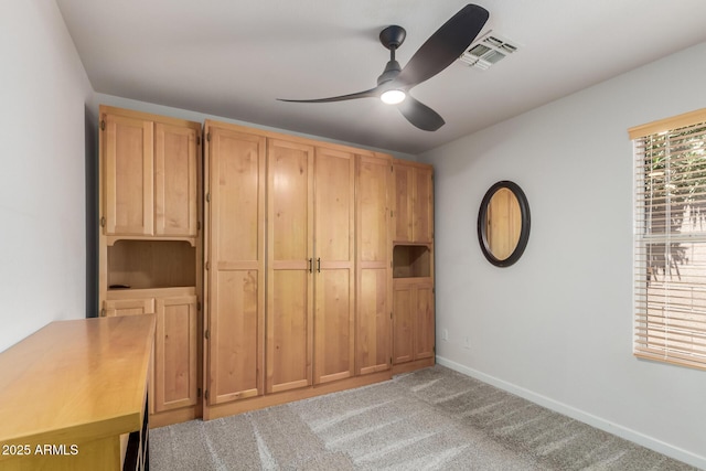 unfurnished bedroom with light carpet, baseboards, and a ceiling fan