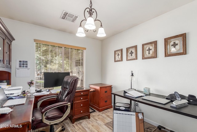 home office featuring a chandelier, light wood-style floors, and plenty of natural light