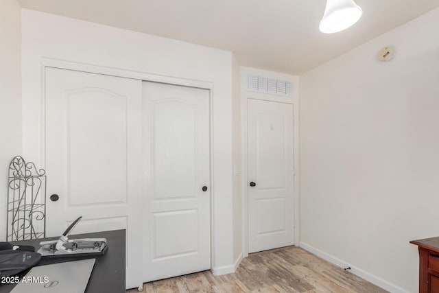 home office with light wood-type flooring and baseboards