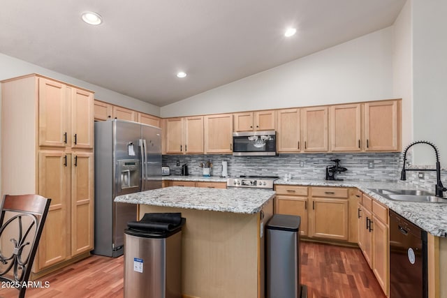 kitchen with stainless steel appliances, a sink, light brown cabinetry, vaulted ceiling, and dark wood-style flooring