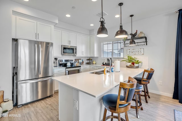 4100 S Pinelake Way Unit 149, Chandler, AZ 85249 - kitchen with appliances with stainless steel finishes, a breakfast bar, a peninsula, light wood-type flooring, and light countertops