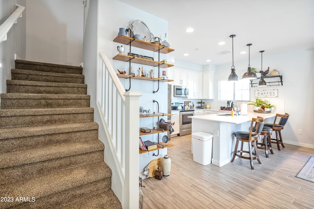 4100 S Pinelake Way Unit 149, Chandler, AZ 85249 - kitchen featuring stainless steel appliances, open shelves, a peninsula, a kitchen bar, and white cabinets