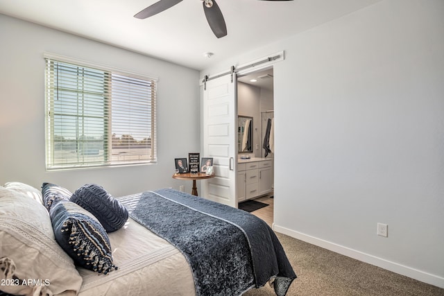4100 S Pinelake Way Unit 149, Chandler, AZ 85249 - carpeted bedroom with a barn door, ceiling fan, and connected bathroom