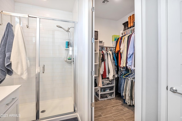 4100 S Pinelake Way Unit 149, Chandler, AZ 85249 - bathroom featuring a walk in closet, a shower stall, wood tiled floors, and vanity