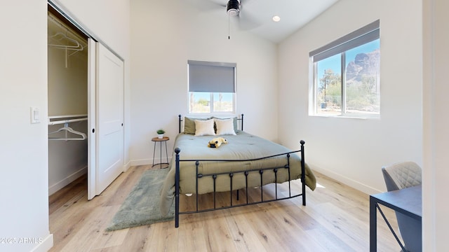 bedroom featuring multiple windows, wood finished floors, and vaulted ceiling