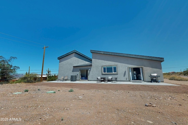 rear view of property featuring stucco siding and a patio