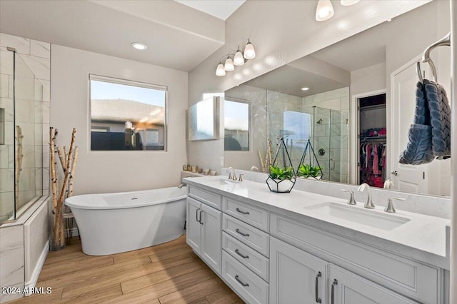 bathroom with plus walk in shower, vanity, and hardwood / wood-style floors