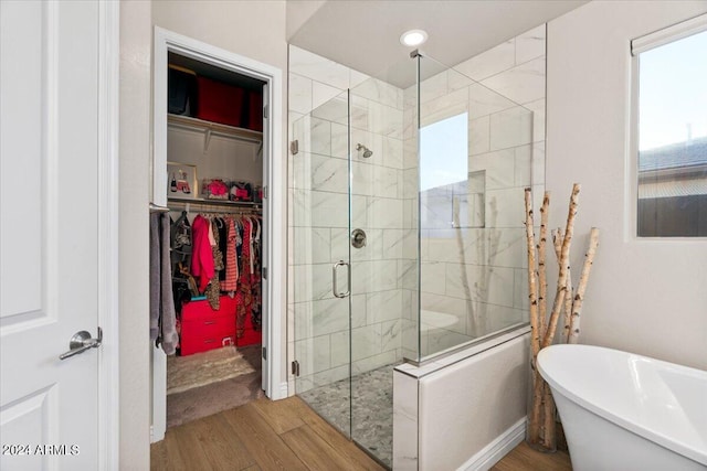 bathroom with shower with separate bathtub and hardwood / wood-style floors