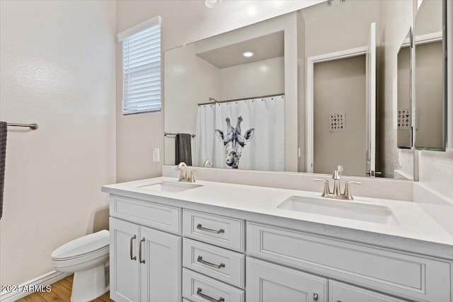 bathroom featuring a shower with shower curtain, hardwood / wood-style flooring, vanity, and toilet