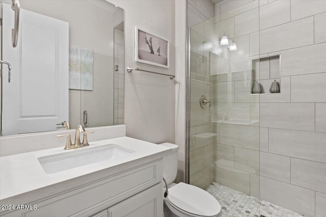 bathroom featuring vanity, toilet, and an enclosed shower