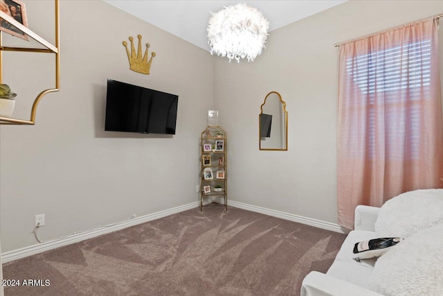 living area featuring carpet flooring and a chandelier