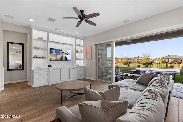 living room with ceiling fan and light hardwood / wood-style flooring