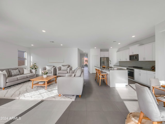 living room with light tile patterned flooring and sink