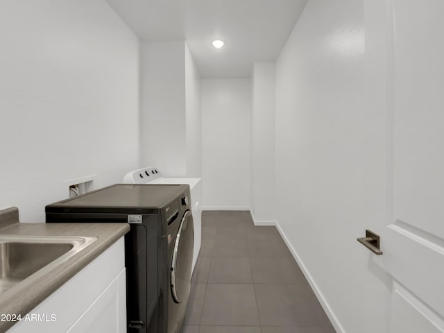 laundry area with independent washer and dryer and dark tile patterned floors