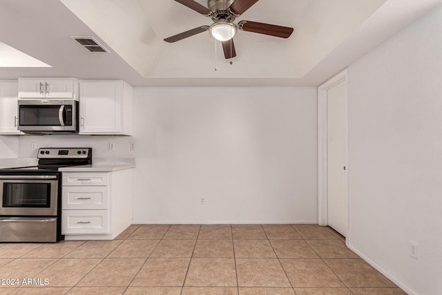 kitchen with ceiling fan, light tile patterned flooring, vaulted ceiling, white cabinets, and appliances with stainless steel finishes