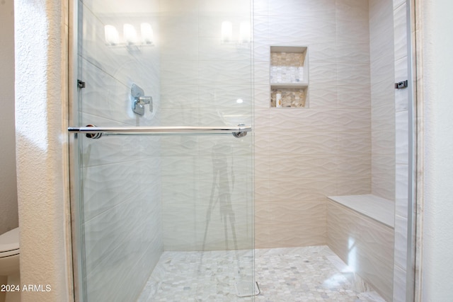 bathroom with toilet and an enclosed shower