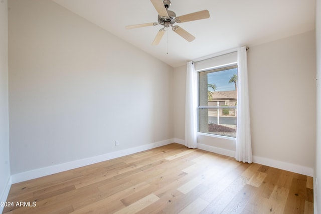 empty room with ceiling fan, light wood-type flooring, and vaulted ceiling