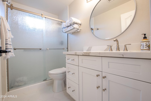 bathroom with tile patterned flooring, vanity, toilet, and a shower with shower door