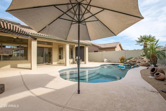 view of swimming pool featuring ceiling fan and a patio