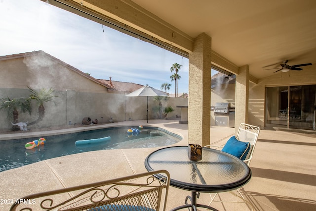 view of pool featuring a patio area, ceiling fan, and grilling area