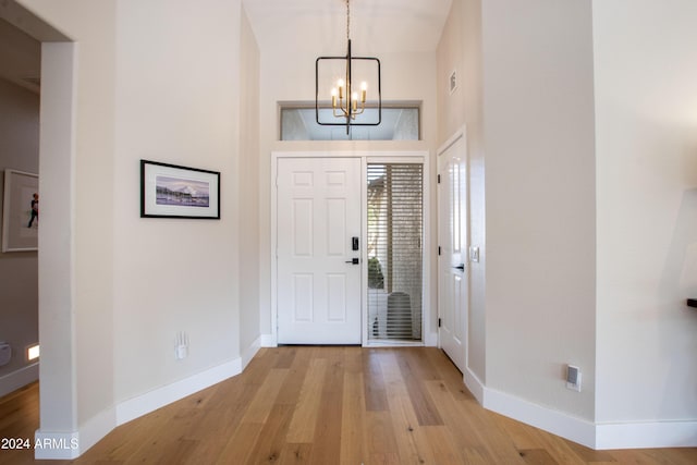 foyer with light hardwood / wood-style floors and a notable chandelier