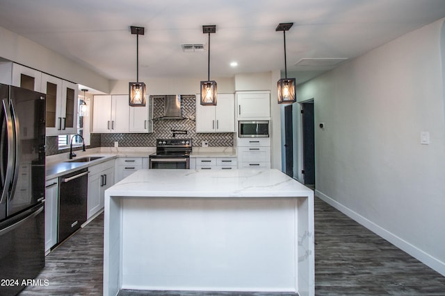 kitchen featuring a center island, sink, white cabinets, wall chimney range hood, and black appliances