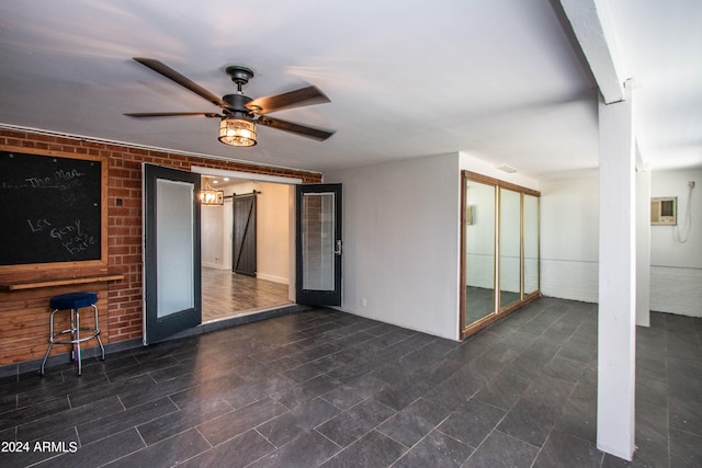 interior space with ceiling fan and a barn door